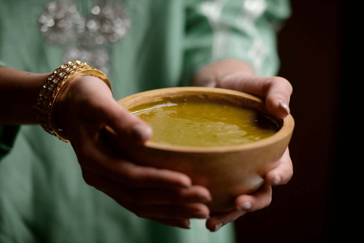 Woman holding a bowl of overnight soaked henna for hair application